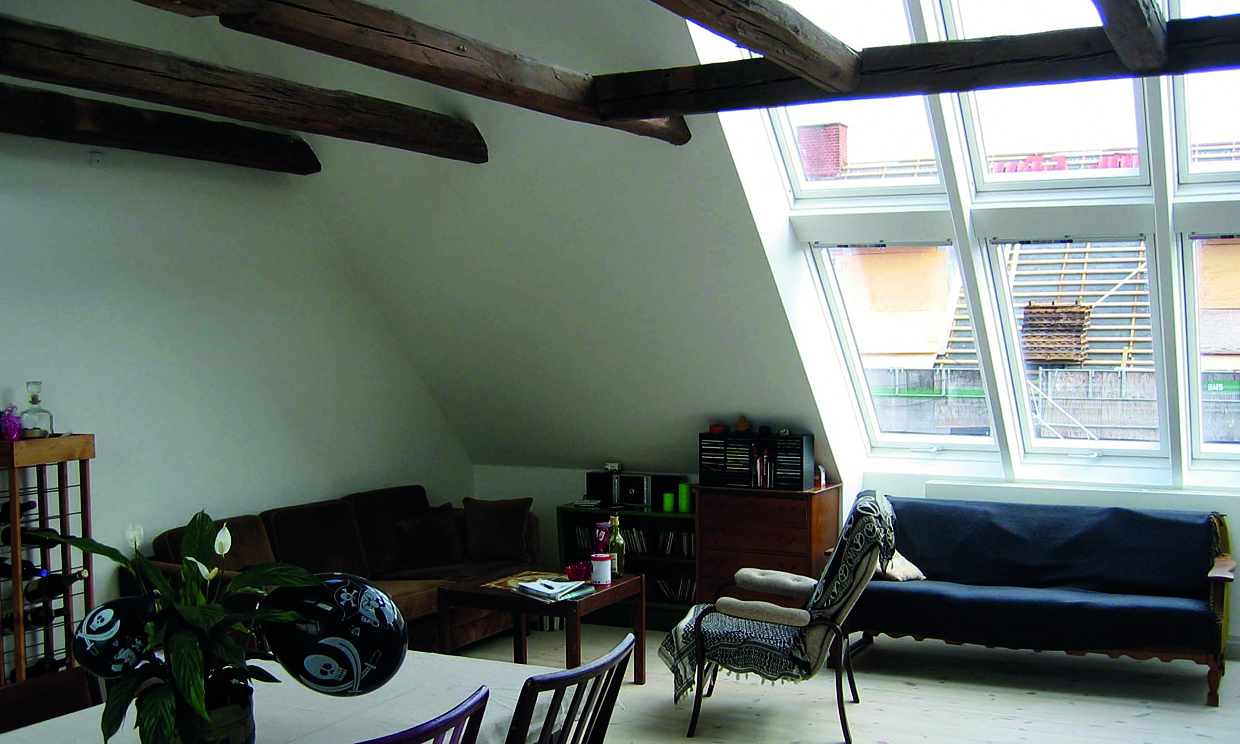 Opholdsrum i tagbolig med stort lysindfald.